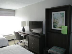 a bedroom with a bed and a desk with a television at Holiday Inn Huntsville - Research Park, an IHG Hotel in Huntsville