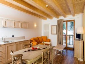 eine Küche und ein Wohnzimmer mit einem Tisch und einem Sofa in der Unterkunft Borgo Fantino - Residenze e Alloggi Vacanza in Limone Piemonte