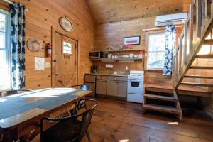 a kitchen with a table and a staircase in a cabin at Paradise Hills, Winery Resort & Spa in Blairsville