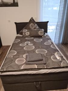 uma cama com um edredão castanho e branco em Ferienwohnung Andiana em Siegen