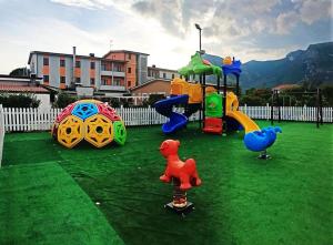 Venafro Palace Hotel في فينافرو: ملعب مع معدات اللعب على العشب