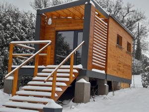 a wooden cabin with stairs in the snow at Lodge avec vue panoramique in Saint-Sorlin