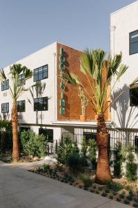 un bâtiment avec des palmiers en face de celui-ci dans l'établissement Silver Lake Pool & Inn, à Los Angeles