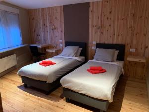 Dos camas en una habitación con toallas rojas. en Huis Buizemont, en Geraardsbergen