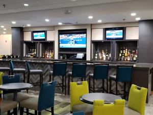 un bar con sillas y mesas coloridas y TV en Holiday Inn Huntsville - Research Park, an IHG Hotel, en Huntsville