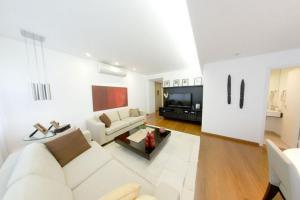 sala de estar con sofá blanco y TV en Leblon House Cupertino perto da praia portaria 24 h garagem ar condicionado e lava seca roupas, en Río de Janeiro