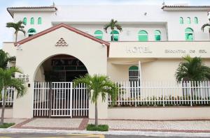 een hotel met een wit hek en palmbomen ervoor bij Hotel Encontro do Sol in Fortaleza