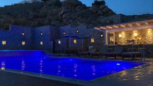 a house with a blue pool at night at Pelagos Studios in Platis Gialos