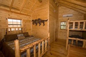 a bedroom of a log cabin with a bed in it at Flying L Ranch Resort in Bandera