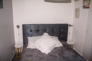ein Bett mit einem schwarzen Kopfteil und einem weißen Kissen in der Unterkunft Appartement palais plages in Cannes