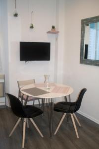 stół i krzesła w pokoju z telewizorem w obiekcie Appartement palais plages w Cannes