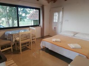 1 dormitorio con cama, mesa y ventana en Apartments Vintijan, en Pula
