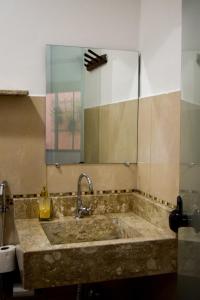 uma casa de banho com um grande lavatório e um espelho. em Pousada Raizes em São Jorge