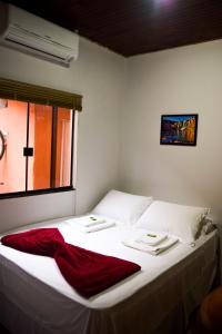 サン・ジョルジェにあるPousada Raizesのベッドルーム1室(白いベッド1台、赤い毛布付)