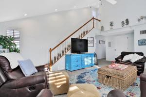 a living room with a couch and a tv at Sol Mate Beach Cottage in St. Pete Beach