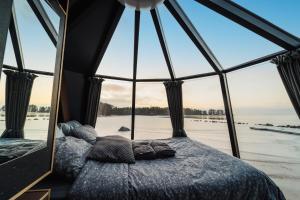 Ce lit se trouve dans un dortoir doté d'une grande fenêtre. dans l'établissement Arctic Lake Experience Oulujärvi Igloos, à Kajaani