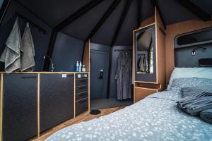 1 dormitorio con 1 cama grande y espejo en Arctic Lake Experience Oulujärvi Igloos en Kajaani