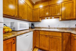a kitchen with wooden cabinets and a white microwave at Owen D in Jackson