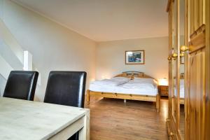 1 dormitorio con 1 cama y 2 sillas negras en Braderuper Heide, en Braderup