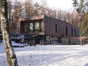Penzion Kůlna في Slatiňany: منزل خشبي في الغابة في الثلج