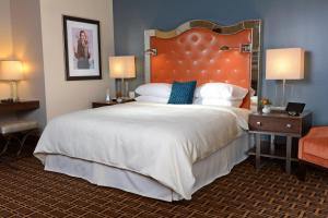 a bedroom with a large bed with a large headboard at The Crawford Hotel in Denver