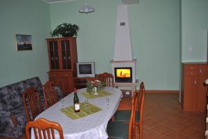 Apartments - Turistična kmetija Vrbnjak في ليوتومير: غرفة طعام مع طاولة ومدفأة