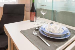 バート・シュタッフェルシュタインにあるruhig gelegenes 1 Zimmer Appartmentのテーブル(ブループレート付)とワイン1本