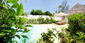 a swimming pool with a bench and an umbrella at ARYA Boutique Resort in Kiwengwa