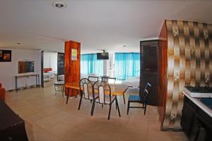 a dining room and living room with a table and chairs at Hotel Condesa Americana Acapulco in Acapulco