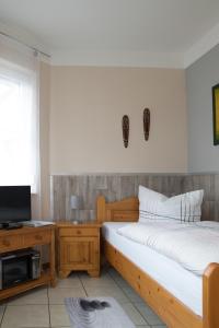 Schlafzimmer mit einem Bett, einem Schreibtisch und einem TV in der Unterkunft ruhig gelegenes 1 Zimmer Appartment in Bad Staffelstein