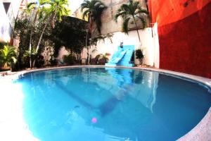 a large blue swimming pool with a slide at Hotel Condesa Americana Acapulco in Acapulco +20 photos