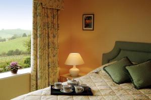 a bedroom with a bed with a tray with cups on it at Shallowdale House in Helmsley