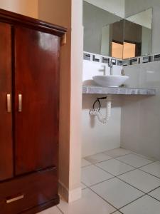 a bathroom with a sink and a mirror at Hotel San Jose Hostal in San Salvador