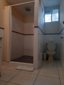 a bathroom with a shower with a toilet at Hotel San Jose Hostal in San Salvador
