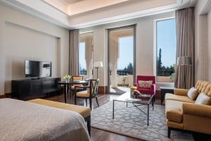 une chambre d'hôtel avec un lit et un salon dans l'établissement The Oberoi Marrakech, à Marrakech