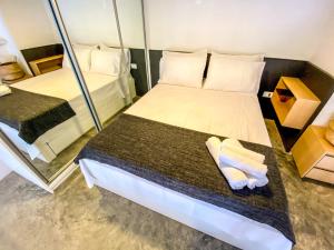 Habitación pequeña con 2 camas y espejo. en 45LOFT EM DE MARILIA TODO DECORADO/ARCOND, en Marília
