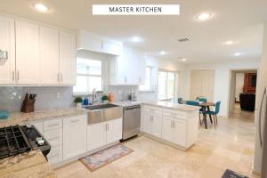 a kitchen with white cabinets and a table in it at Vacation Pool House in the Serene Wilderness - Robert E Lee in Conroe