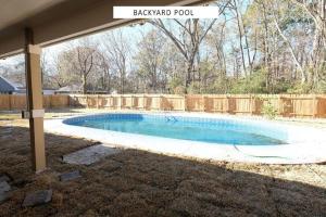 una piscina en un patio trasero con una valla de madera en Vacation Pool House in the Serene Wilderness - Robert E Lee, en Conroe