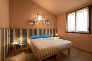 a bedroom with a bed with blue pillows at Leonardo Resort in Imperia