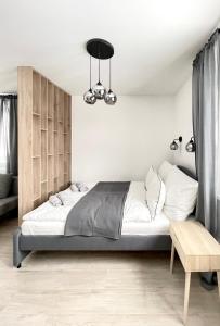 a bedroom with a large bed and a chandelier at Apartament Górska in Świeradów-Zdrój