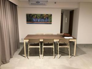 奧林匹亞的住宿－Apto Master em Olímpia Park Resort，一张餐桌,配有三把椅子和一幅画