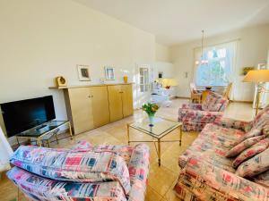a living room with two couches and a tv at Villa Caprivi 1 in Heringsdorf