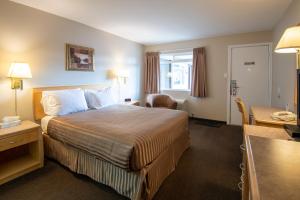 a hotel room with a bed and a desk at Canadas Best Value Inn-Prince George in Prince George