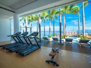 a gym with a view of the ocean and palm trees at PIER 57 - 609 2 BR Amazing Roof in Romantic Zone in Puerto Vallarta