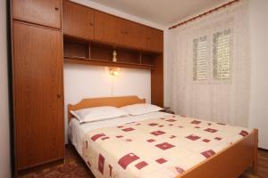 1 dormitorio con 1 cama y armario de madera en Rooms Mare - economy rooms, en Sućuraj