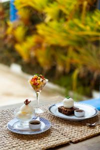 - une table avec deux assiettes de nourriture et une boisson dans l'établissement Hotel Solar do Arco, à Cabo Frio