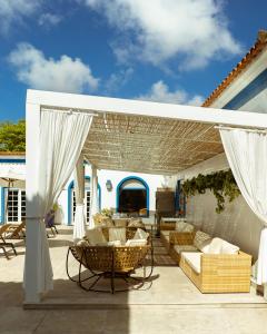 een patio met banken en stoelen onder een pergola bij Hotel Solar do Arco in Cabo Frio