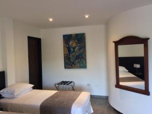 a hotel room with two beds and a mirror at Hotel Sierra de la Cruz in Valle de San José