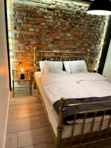 a bed in a room with a brick wall at Apartament2 Tri-City Oliwa Ogród, prywatne wejście in Gdańsk