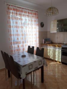 een keuken met een tafel en stoelen bij Apartment Banjol 137 in Rab